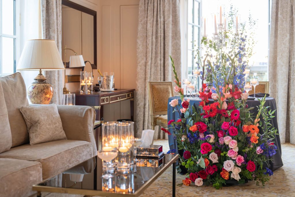 Luxurious private dining after a proposal in Paris. The Shangri-La Hotel's exclusive Gustave Eiffel Suite sets the scene for an intimate celebration. A couple enjoys a romantic dinner served by a private butler amidst a colorful floral wonderland.