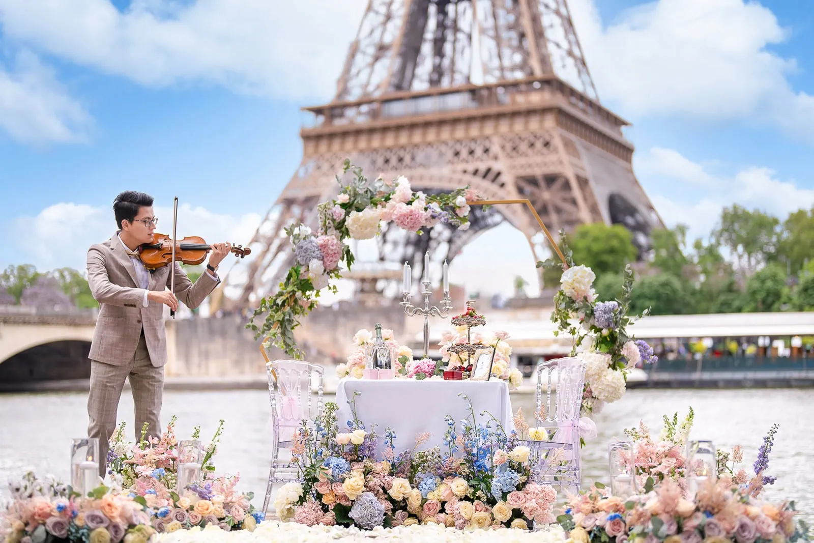 Luxury Paris picnic proposal at Seine River with floral arch, Dom Pérignon, and Eiffel Tower view