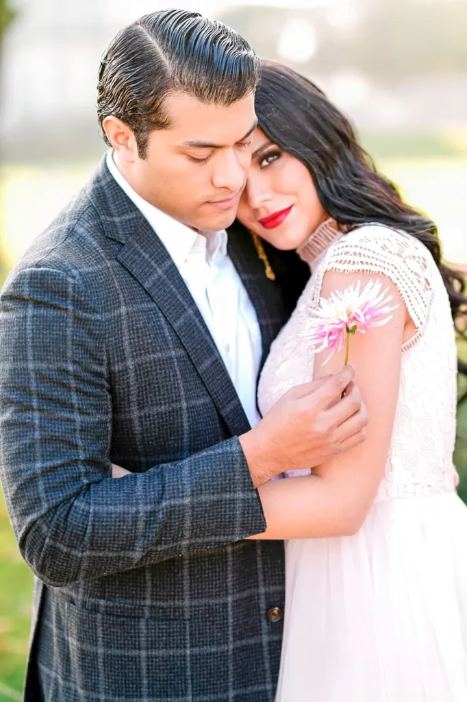 Intimate couple photography in Paris with man holding flower embracing woman