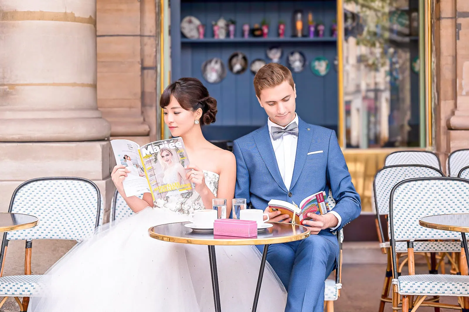Stylish engaged couple at a Parisian café near Palais Royal enjoying coffee and macarons during their Paris engagement photo session.
