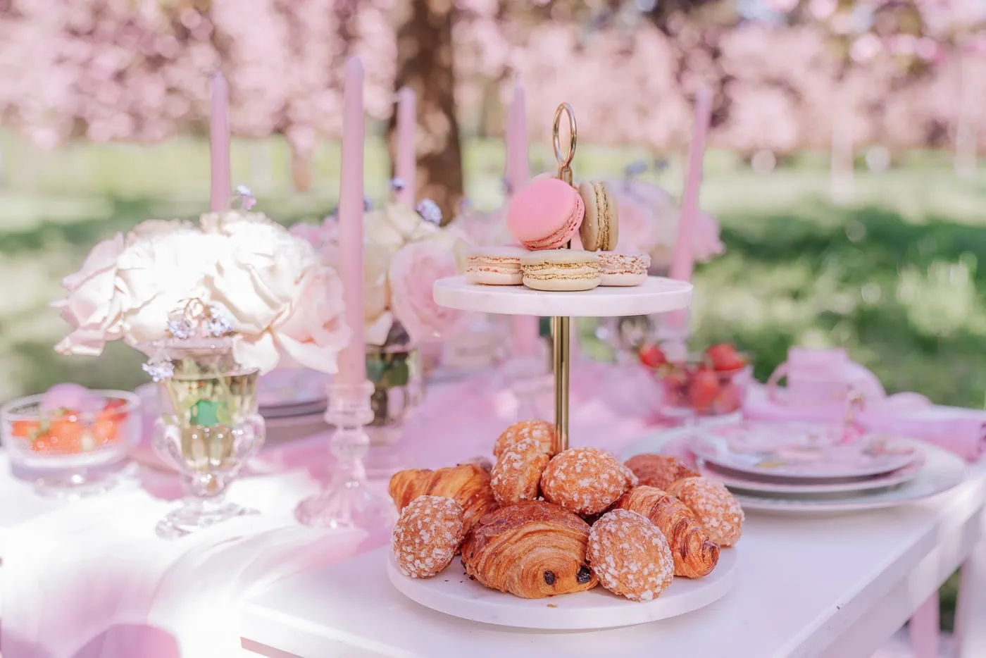 Luxury Paris picnic proposal under blooming cherry blossoms at Parc des Sceaux with elegant table setting, flowers, and gourmet French delicacies