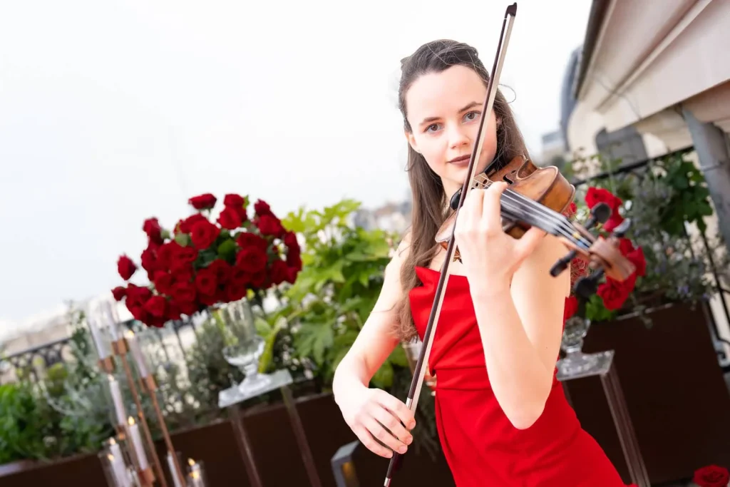A super talented female violinist seen here playing in an elegant red gown during a Paris Violinist Proposal. We can arrange your master violinist at any location you desire.